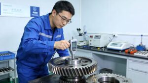 Quality engineer using a high-precision electronic gauge to inspect dimensional tolerances and surface integrity of a large helical gear in a lab.